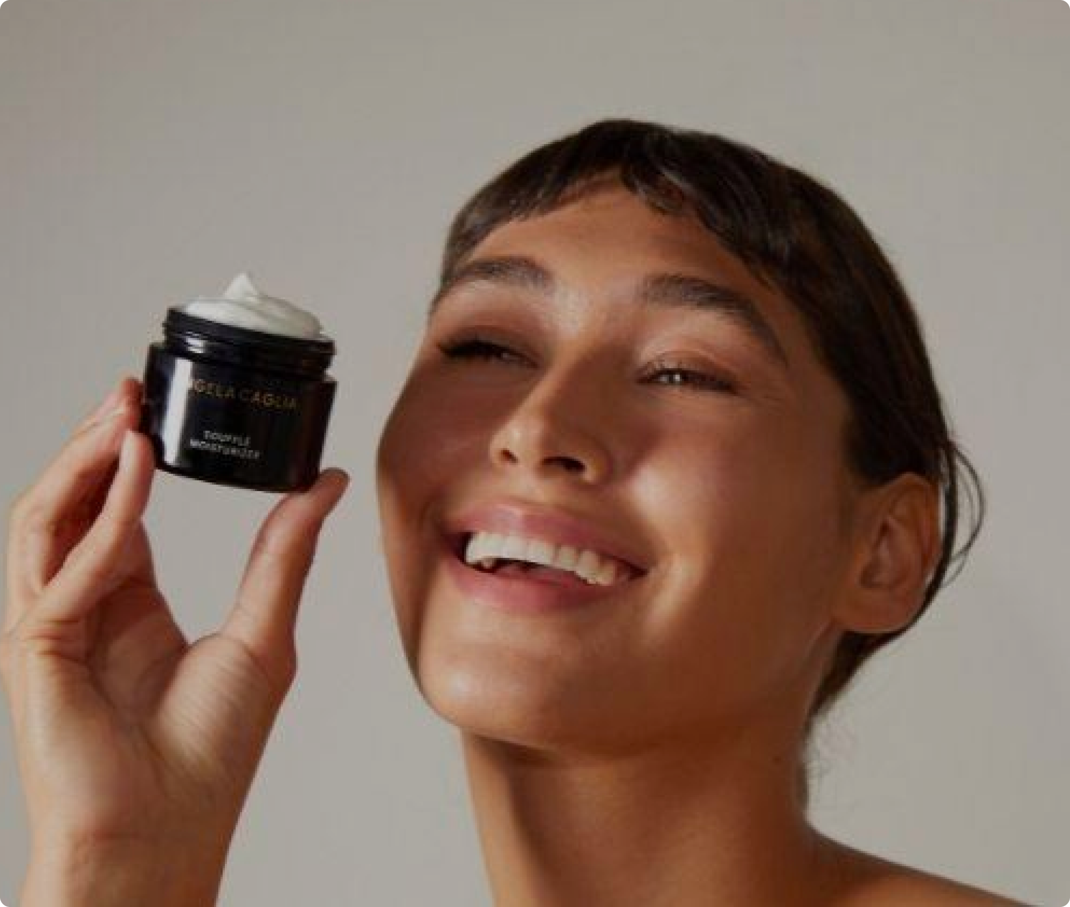 Close up model holding Souffle Moisturizer jar